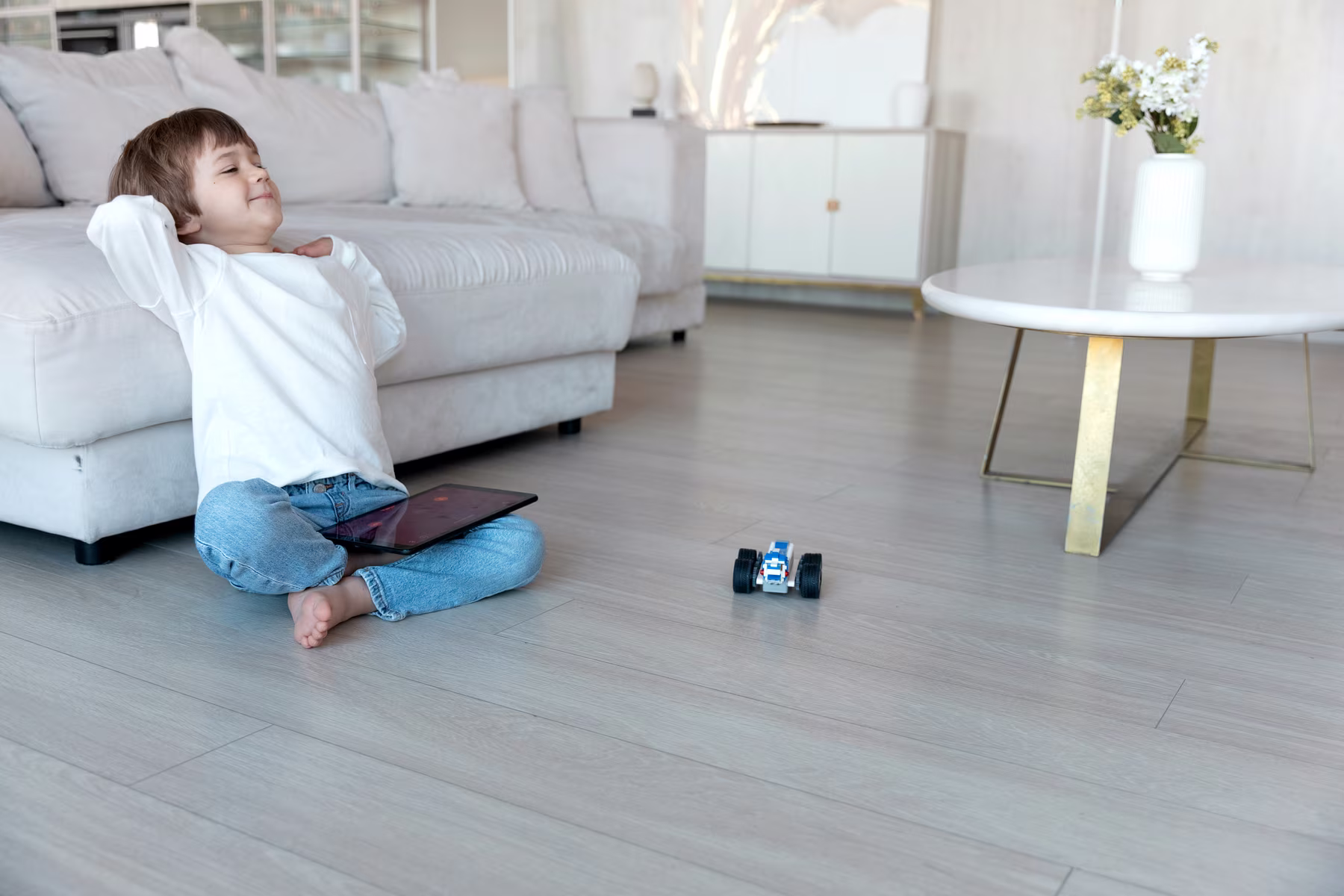 Young child playing on clean luxury vinyl plank flooring in a bright living room.